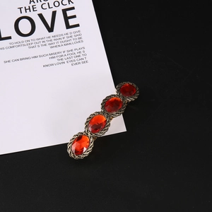 Vintage hair clip with four red oval gemstones and antique gold woven metal base