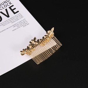Detail showing golden leaf and butterfly metal hair comb with intricate textures