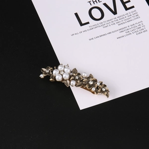Detailed view of vintage bronze flower hair clip with pearls and crystal rhinestones