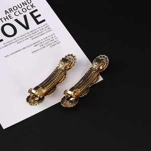 Macro detail of retro gold alloy hair clips showing wave design and metal mechanism