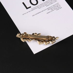 Golden metal leaf hair clip with elegant floral design and non-slip spring mechanism