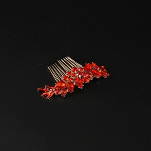 Detail of red crystal hair comb with waterdrop rhinestones on elegant gold plating
