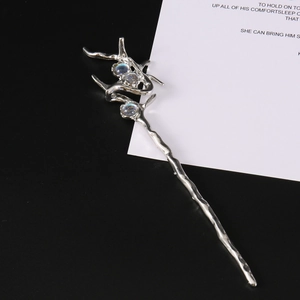 Detailed view of silver branch hair pin with three iridescent rhinestones on a white card