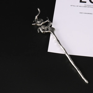 Macro shot of a silver irregular lava hair stick with liquid metal art texture