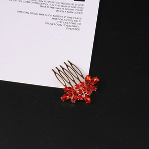 Dettaglio macro del pettine per capelli vintage a fiore con strass rossi radiosi