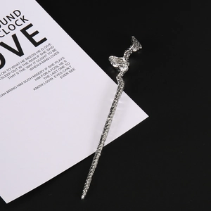 Macro detail of silver hair pin with irregular textured metal surface and wavy snake shape