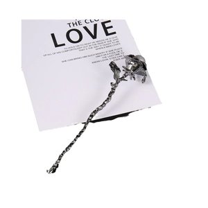 Elegant silver metal rose hair pin with leaf and thorn detail on a white love card