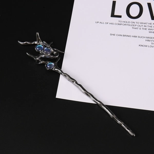 Macro shot of silver vintage hair stick featuring three glowing blue moonstones and fluid design