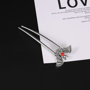 Gothic bat hair stick with red bead in vintage silver finish on split background