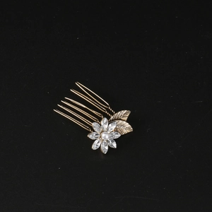 Detail of flower hair comb with colorful rhinestones and white pearl on gold alloy