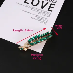 Détail de la pince à cheveux feuille avec strass vert olive sur base dorée