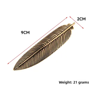 Detailed macro view showing a 9cm vintage gold feather hair clip with intricate textures