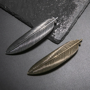 Vintage style feather hair clips in antique silver and bronze with detailed metallic texture