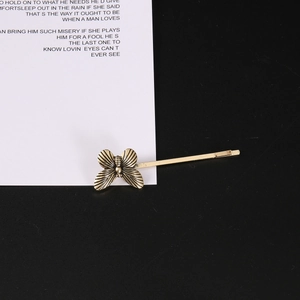 Vintage bronze butterfly hair clip with detailed metallic wings on a minimal background