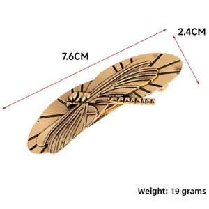 Detail showing the vintage brass dragonfly hair clip with scale and weight measurements