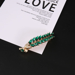 Pince à cheveux feuille dorée avec cristaux verts et strass blancs brillants