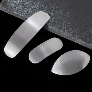 Vue macro de barrettes ovales en métal argenté brossé avec une texture mate chic