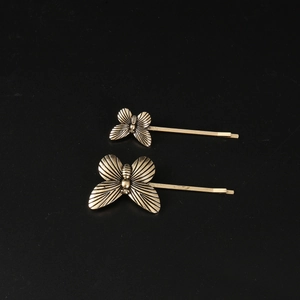 Detailed macro view of vintage bronze butterfly hair clips with intricate metal engraving