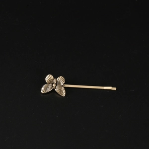 Vintage gold butterfly hair clip with metallic texture on elegant black background