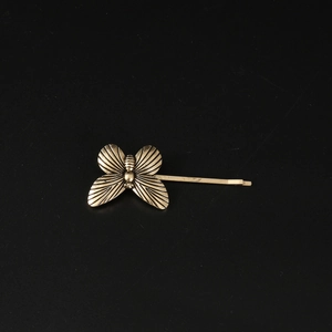 Vintage bronze butterfly hair clip with detailed wing engravings on a black background