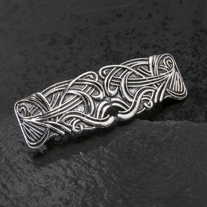 Close-up of vintage bronze hair clip with intricate Celtic knot engraving and hollow design