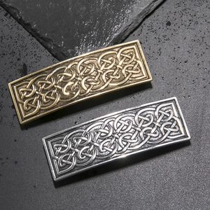 Detail of vintage Celtic knot engraved metal hair clips in antique gold and silver finishes