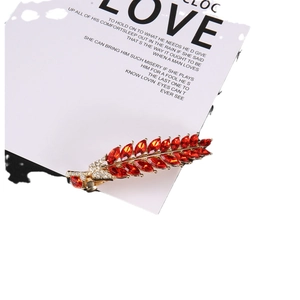 Barrette élégante en forme de feuille dorée avec strass marquise rouges sur carte
