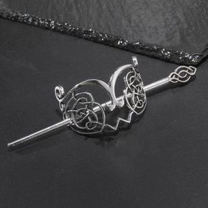 Detail of silver Celtic knot metal hair slide set with hairpin on black stone background