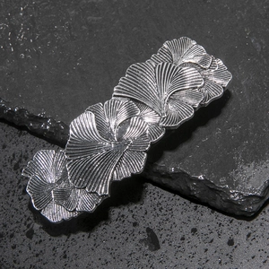Macro detail of vintage silver leaf hair clip showing realistic ginkgo vein textures