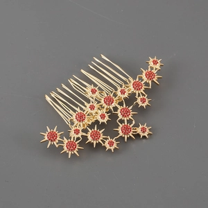 Close-up of golden hair comb featuring star motifs and sparkling red rhinestones