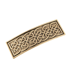 Macro view of vintage bronze alloy hair clip featuring intricate Celtic knot relief patterns