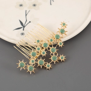 Detail of golden hair comb featuring green crystal starburst flower ornaments