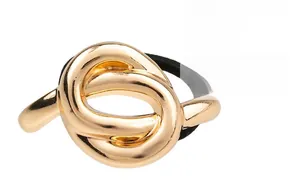 Detail view of a gold alloy hair tie featuring a polished metal knot and black elastic band