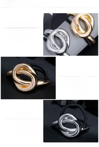 Detail view of the polished irregular metal knot hair tie in gold and silver finish