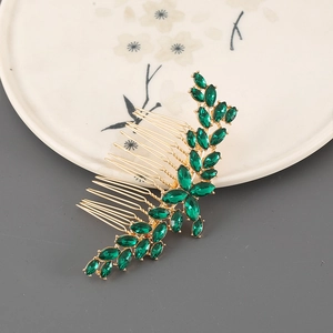Elegant gold bridal hair comb with emerald green zircons in a leaf vine design