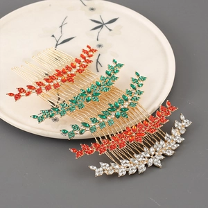Dettaglio dei pettini per capelli dorati con strass marquise in rosso, verde e bianco