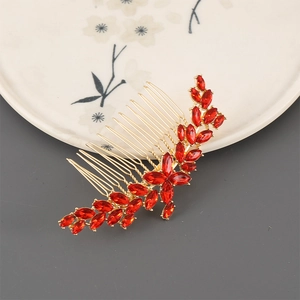 Detail of bridal hair comb with red marquise rhinestones and gold leaf design