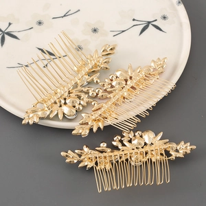 Detailed view of three gold leaf hair combs with sparkling rhinestones on ceramic