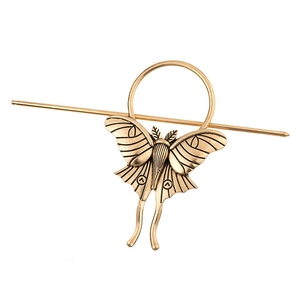 Detailed macro view of vintage bronze butterfly hair stick with embossed wings texture