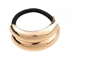 Macro detail of the golden electroplated alloy geometric hair ring with metallic finish