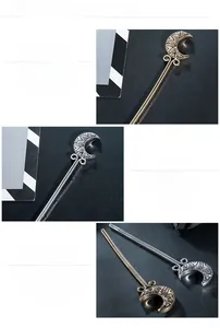 Macro detail of crescent moon hair stick showing golden and silver finishes with patterns