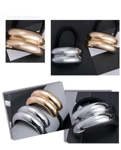 Detailed close-up of retro geometric gold and silver capsule-shaped metal hair ties