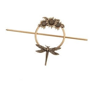 Detail of vintage bronze hair pin with sunflower reliefs and dragonfly metal texture