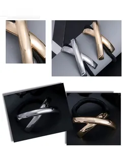 Detail of high-elasticity black hair ties with X-shaped gold and silver metal accents