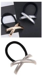 Macro detail of high-elastic black hair ties with polished gold and silver X-shaped metal clips