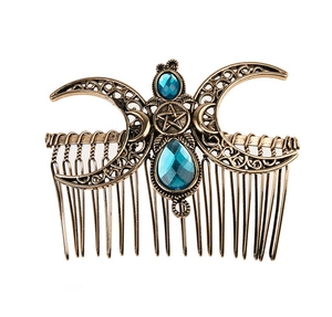 Detail of vintage bronze hair comb featuring blue gemstones and moon star design