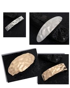 Detailed macro view of irregular geometric hair clips with hammered silver and gold metal texture