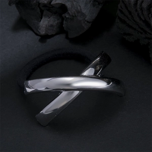Minimalist elastic hair tie with a silver metallic X-shaped charm on dark mineral stone