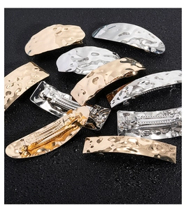 Detail of gold and silver alloy hair clips with irregular hammered texture and spring clasp