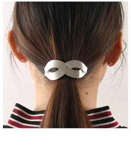 Detail of matte silver infinity symbol hair clip showing brushed metal texture on hair